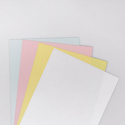 Three sheets of colored paper (pink, yellow, white) on a light gray background