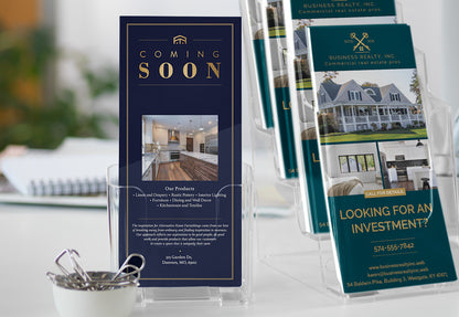 Real estate brochures on a table with a focus on 'Coming Soon' and investment opportunities.